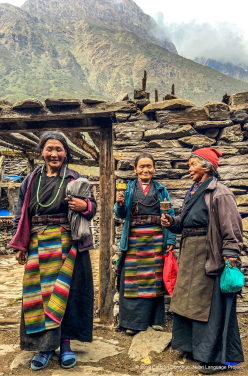 Three women standing in front of a typical home in the main path that runs through Sama village (3550m). They are wearing the typical Tibetan-style Nubri dress that most women over about 30 wear. They are on their way to the eye screening clinic.